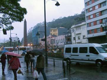 Na rua do imperador, pessoas caminham pelas calçadas molhadas e escorregadias Na rua do imperador, pessoas caminham pelas calçadas molhadas e escorregadias